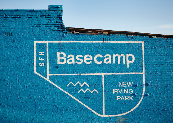 the basecamp sfh logo painted on a blue brick wall