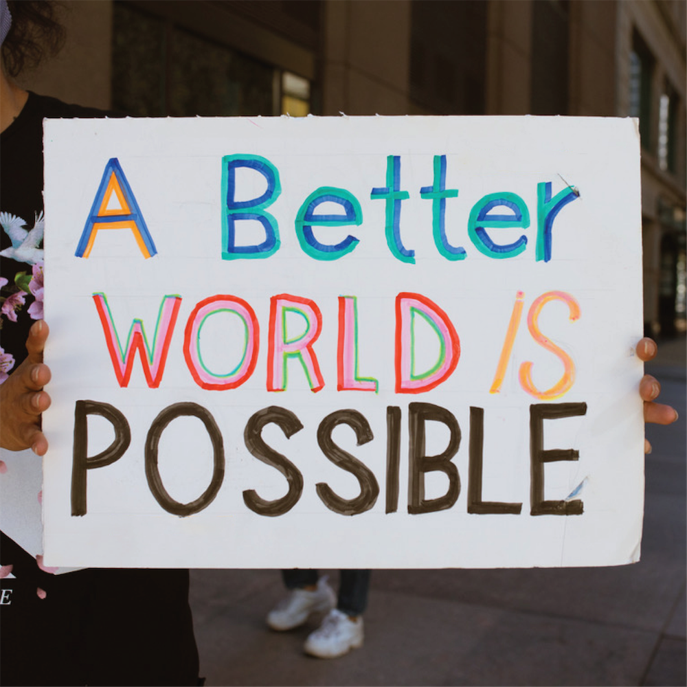 Protester in Chicago holds up a sign that reads "A better world is possible"