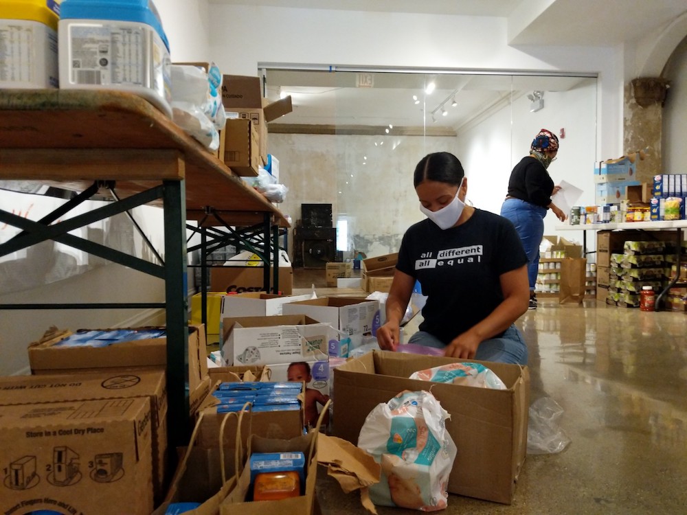 A volunteer packs bags at a community-led food bank